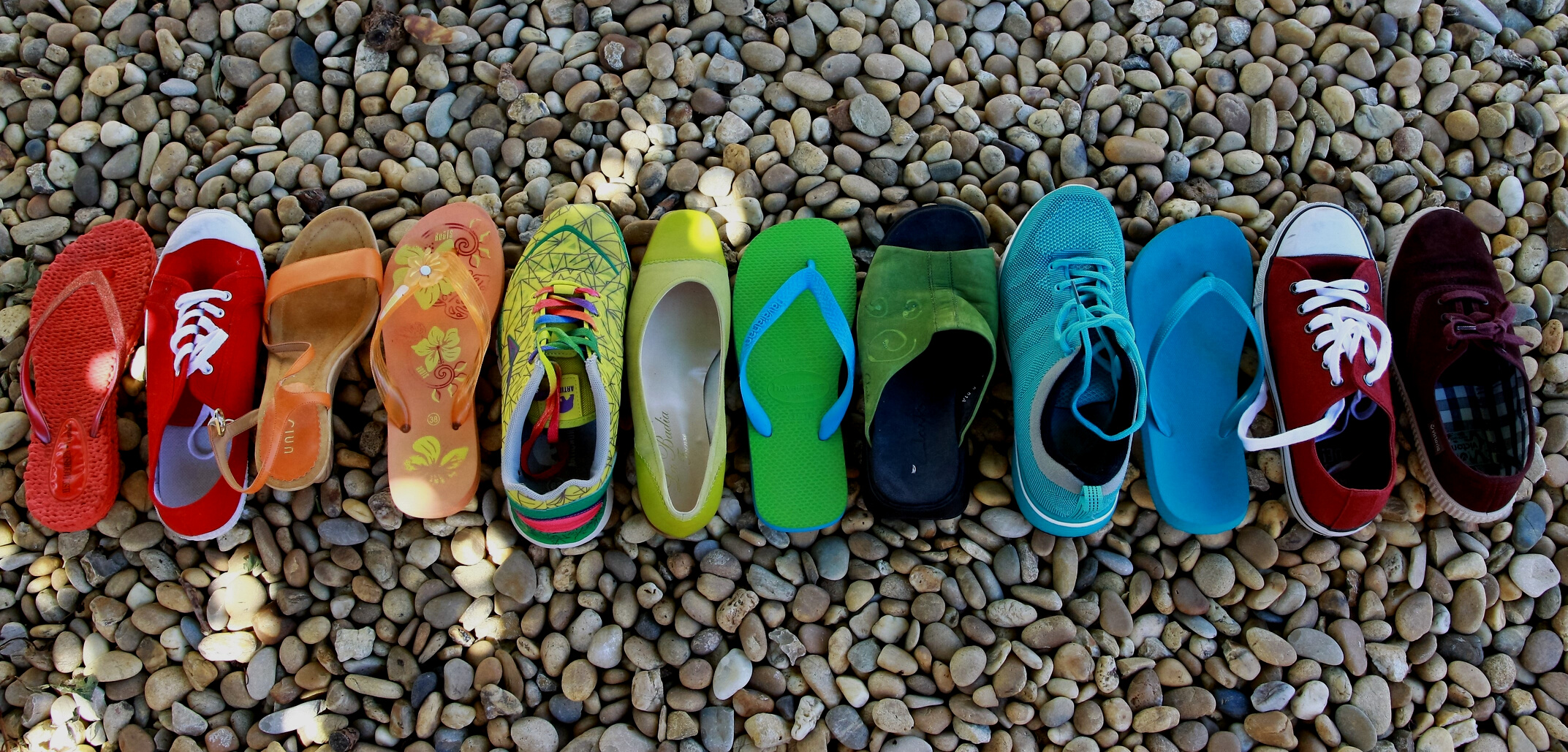 Colorful Shoes and Slippers Arranged on Pebbles
